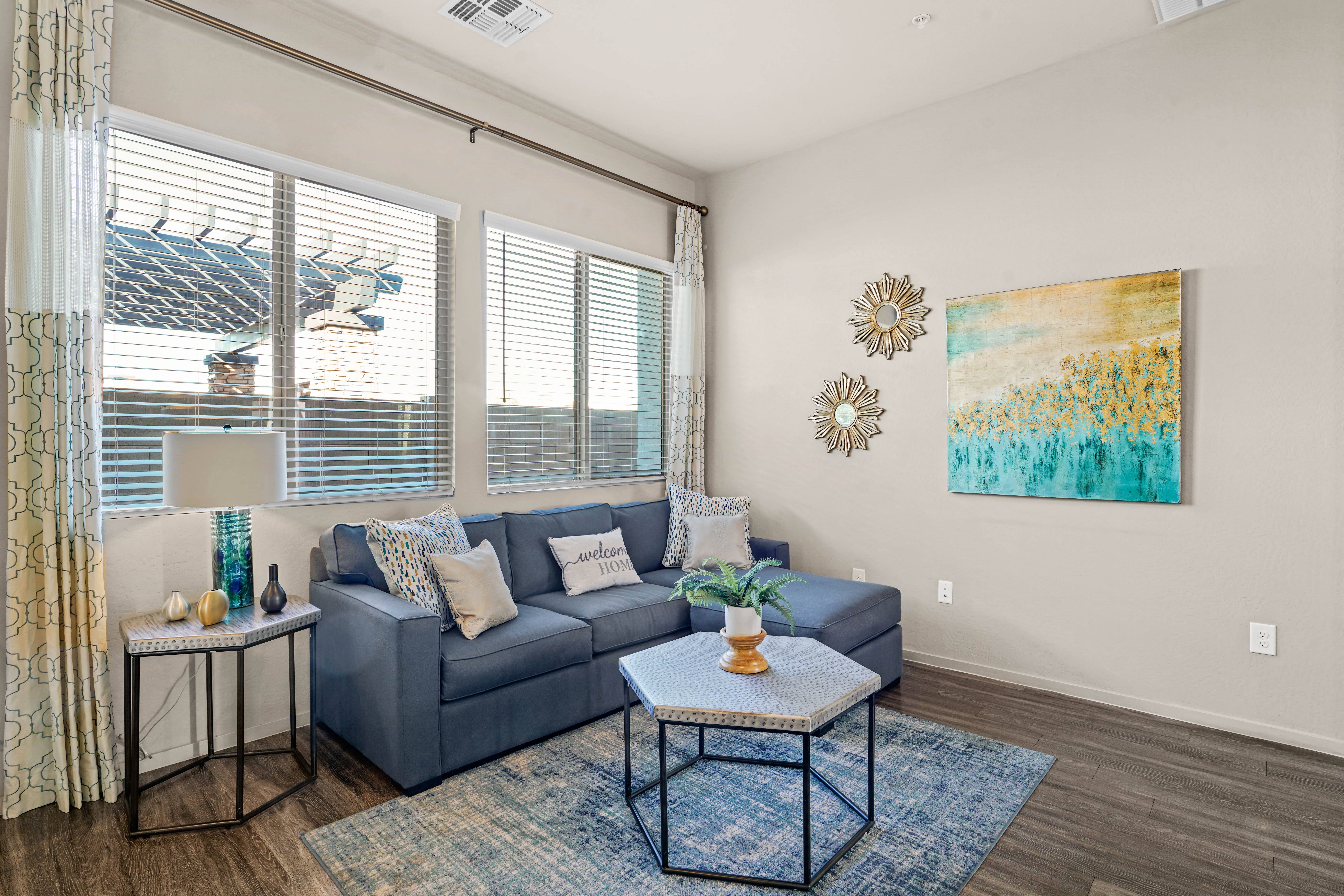 a living room with a blue couch and a coffee table at Olive Queen Creek Apartments, Queen Creek